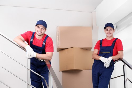 Removal team loading moving boxes and furniture into a van