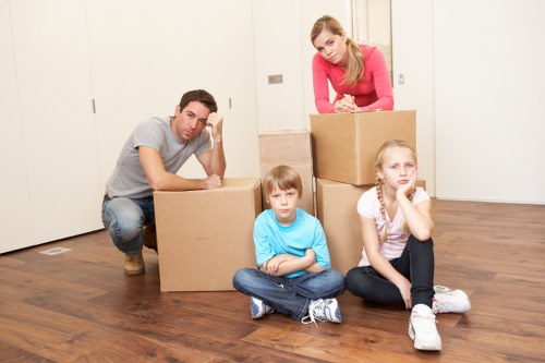 Prepared moving crew handling boxes and furniture in a local property